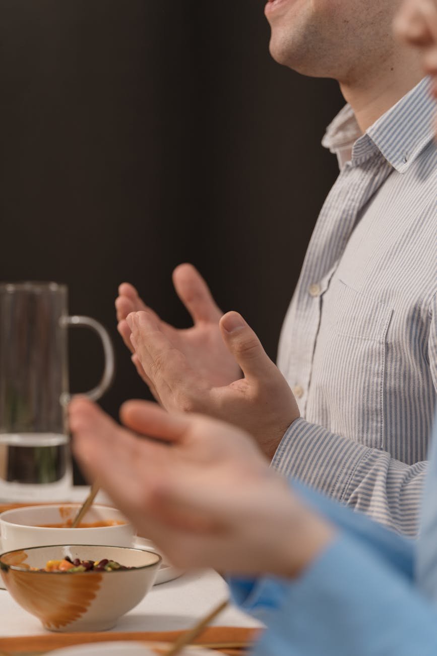 woman and man praying by table