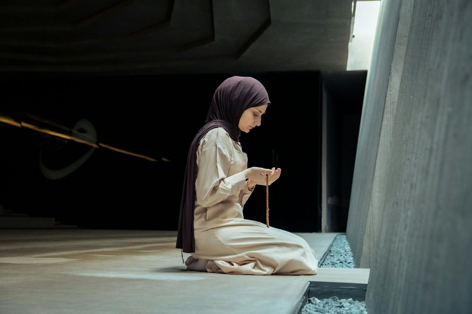woman kneeling and praying at mosque