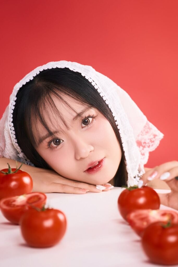 portrait of woman with tomatoes on red backdrop