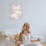 woman in white tank top sitting on bed