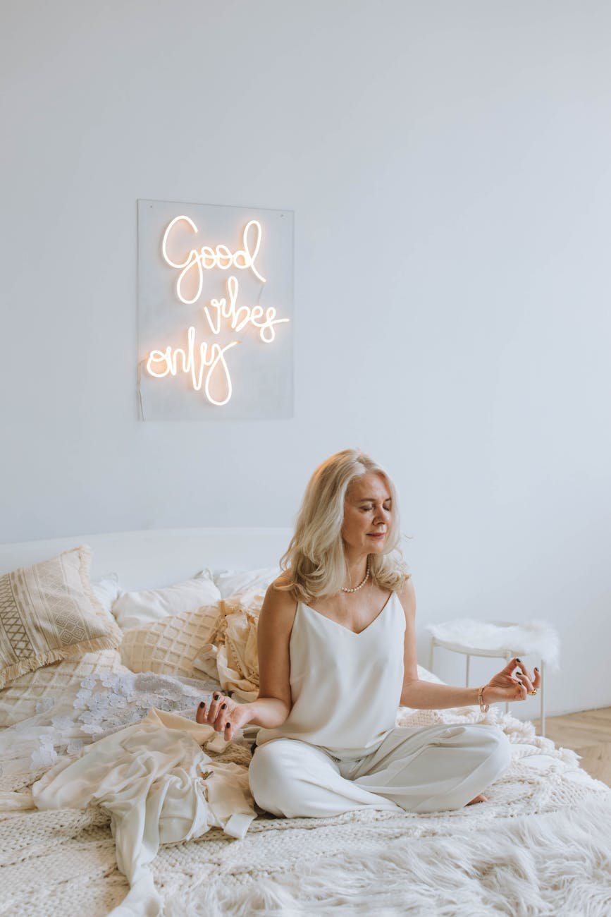 woman in white tank top sitting on bed