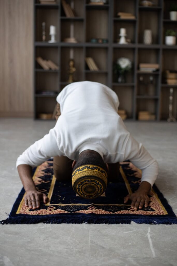 concentrated black man praying on rug at home