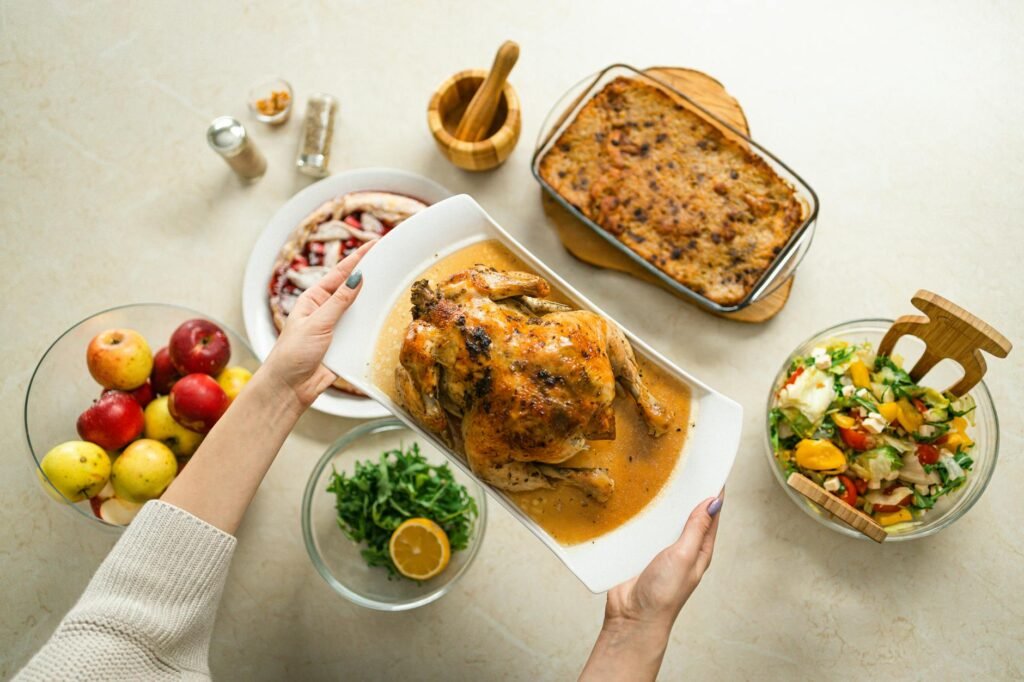 person holding a ceramic plate of roasted chicken