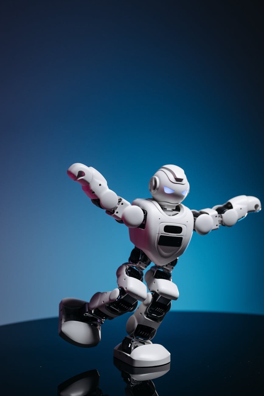a white robot toy with arms and leg raised