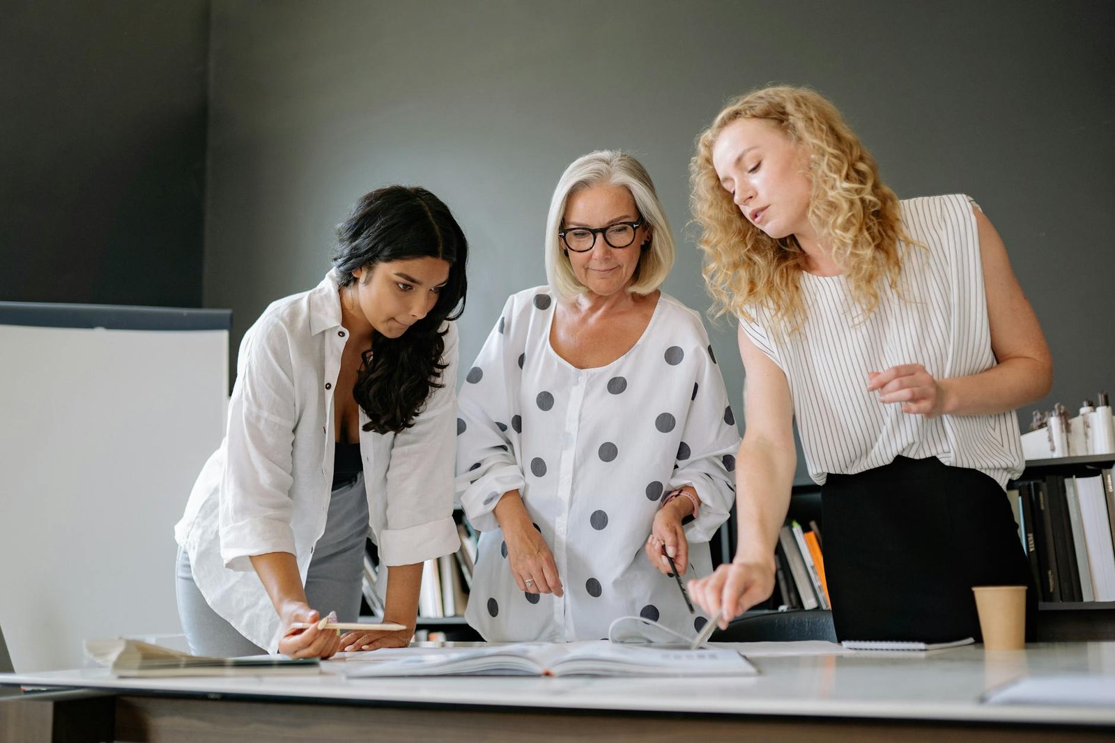 coworkers looking at papers on table in office