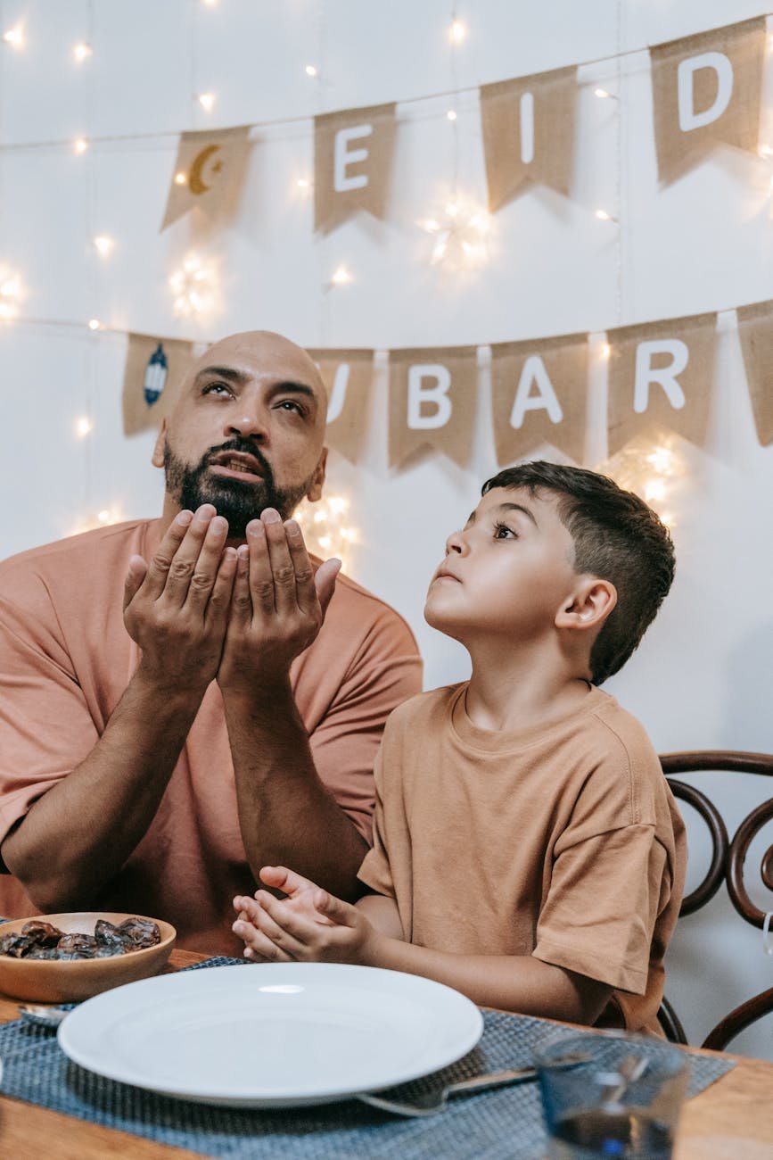 father and son praying at the table