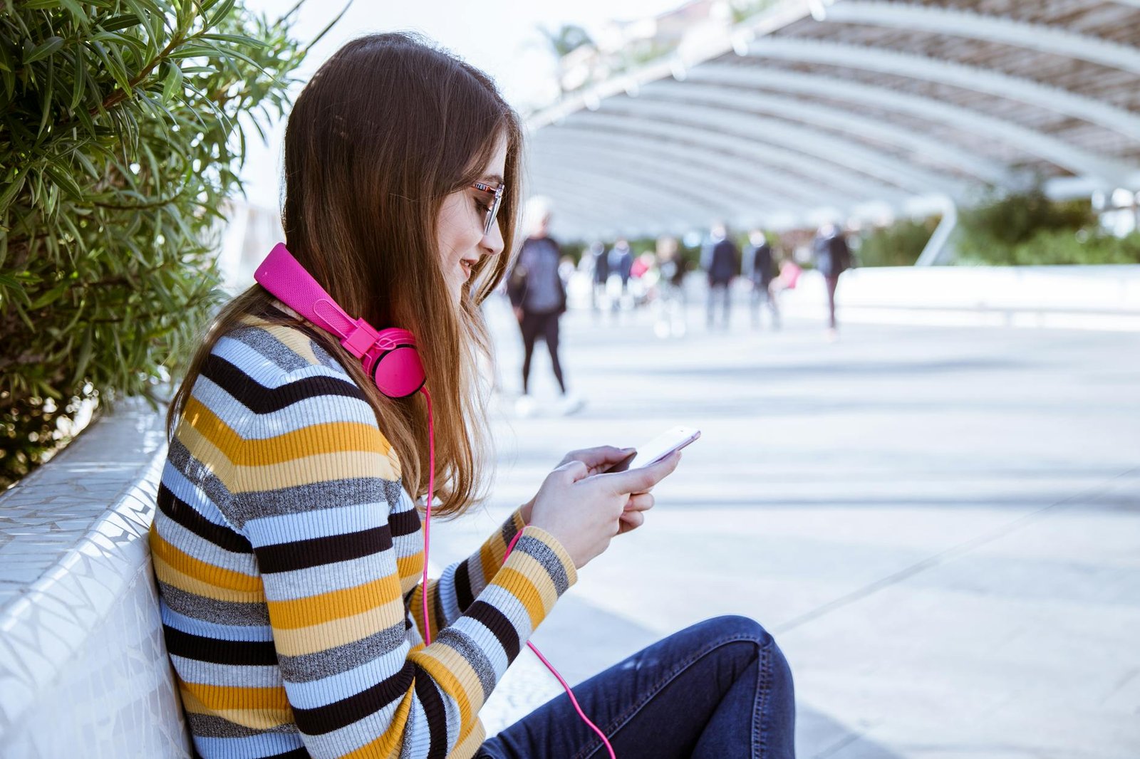 woman sitting outdoors while using smartphone