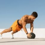 man exercising with medicine ball on rooftop