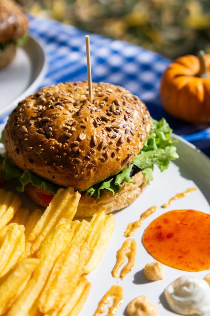 delicious burger with fries on outdoor picnic table
