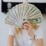 person holding fan of us dollar bills