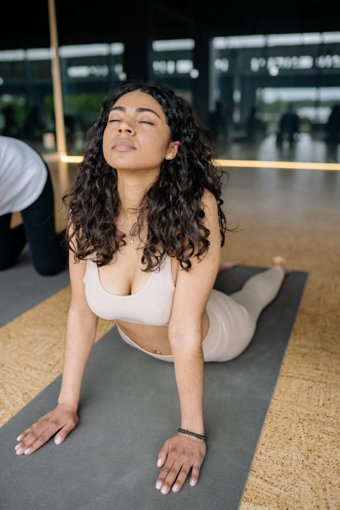 woman in beige brassiere and leggings stretching on the mat