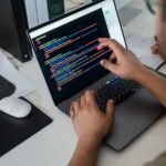 close up of a man pointing code on a laptop screen