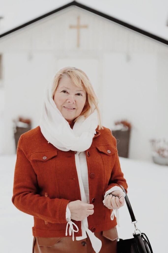 portrait of blonde woman in red jacket and scarf