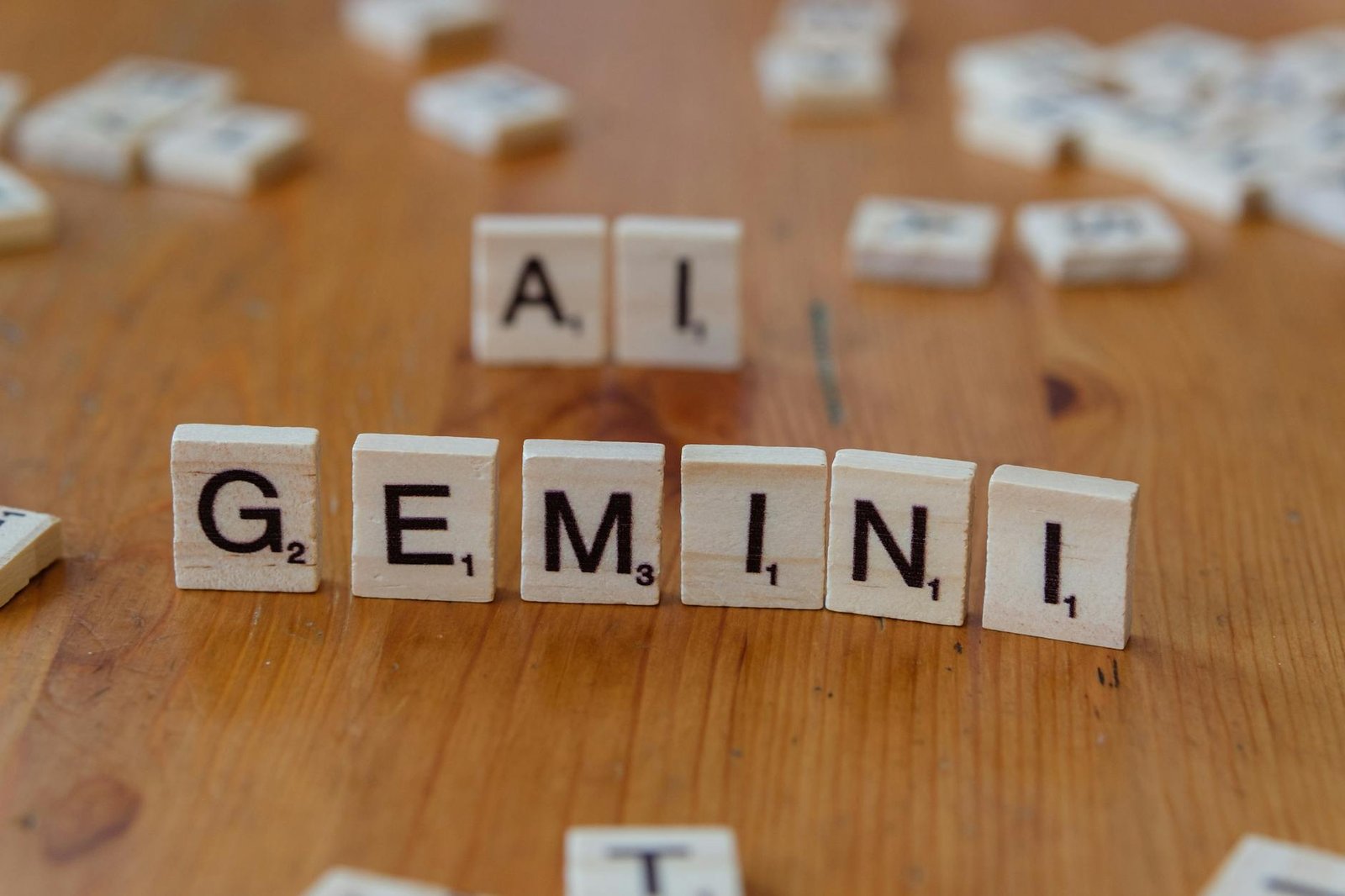 scrabble tiles spelling gemini and ai on wooden surface