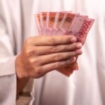 hand holding indonesian rupiah banknotes