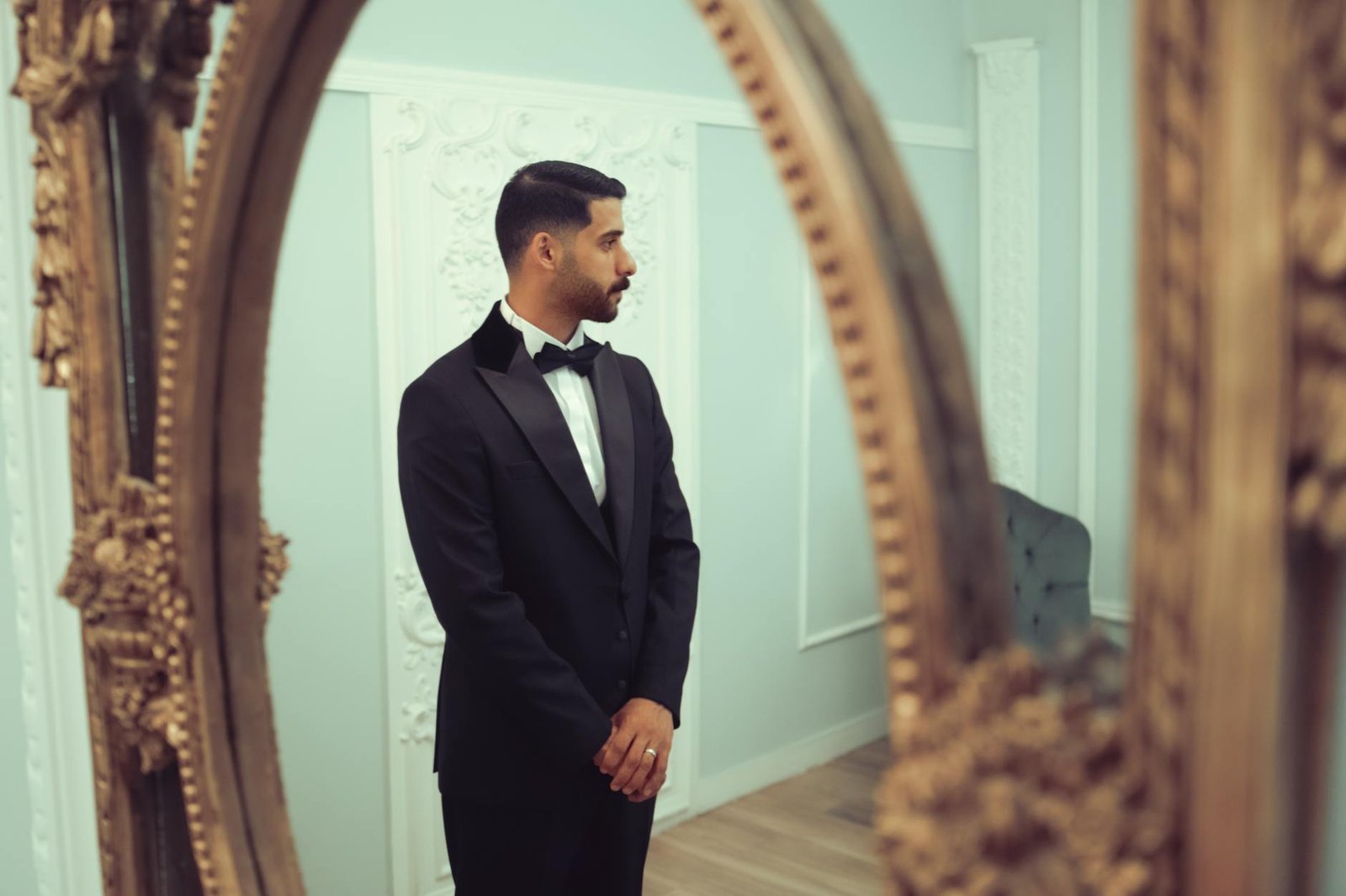 elegant man in tuxedo reflecting in antique mirror