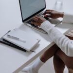person in white long sleeve shirt using macbook pro