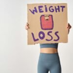 person holding a cardboard with weight loss message