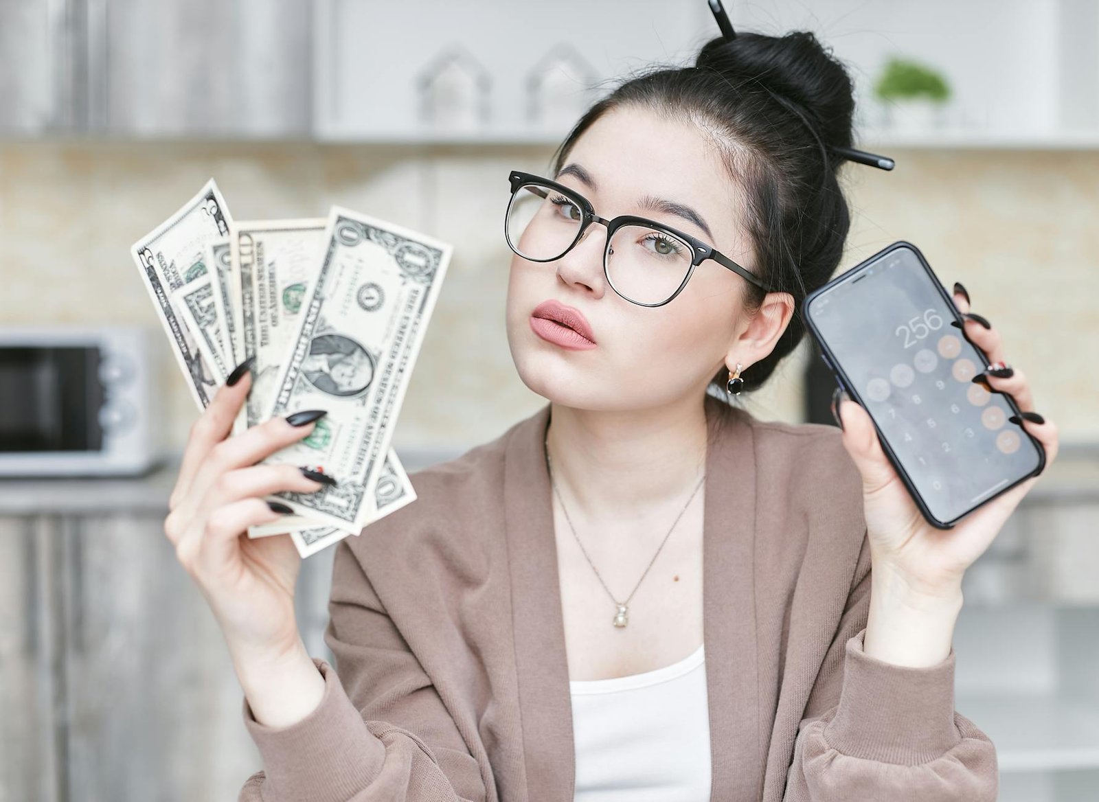 a woman holding smartphone and money