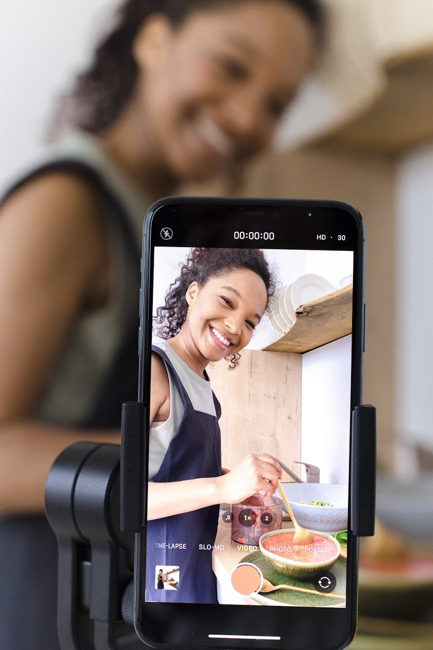 a screen of a smartphone woman smiling while cooking