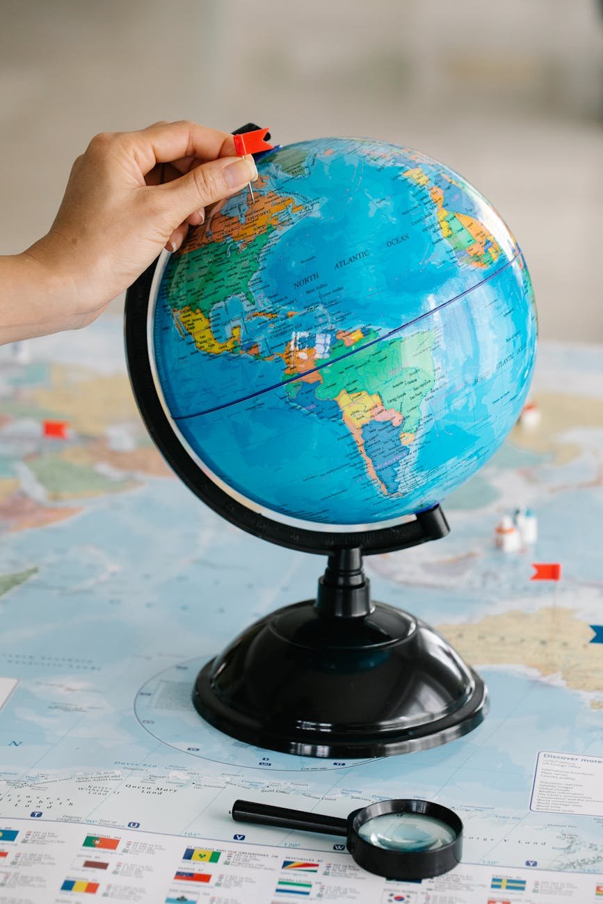person holding a blue desk globe