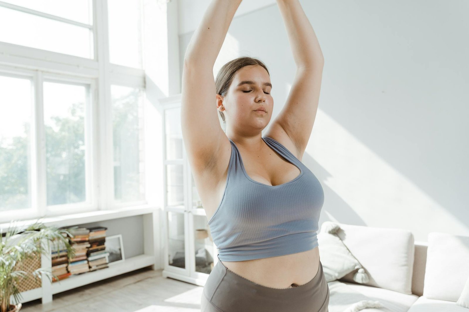woman in blue tank top raising her hands