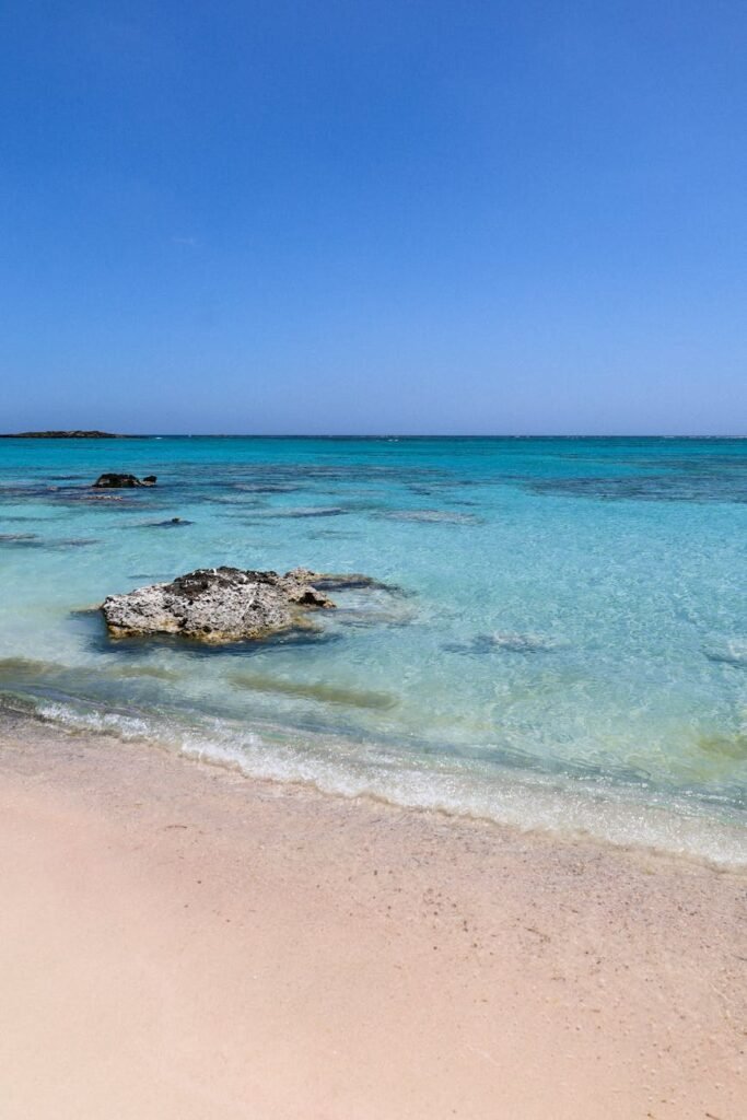 a clear water on the beach under the blue sky