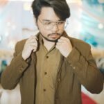 man in brown jacket and jacket fixing collar