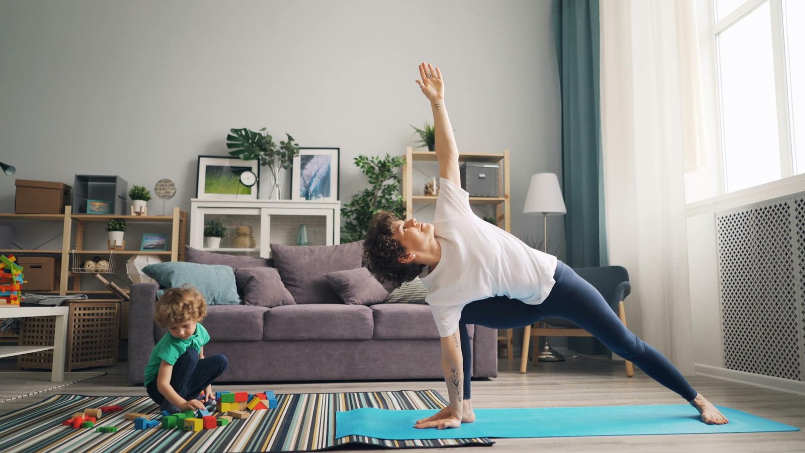 woman exercising yoga and son playing with blocks