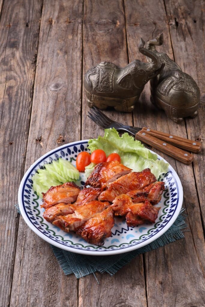 grilled chicken with lettuce and tomatoes on rustic table