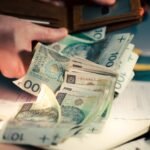 counting polish zloty banknotes from wallet