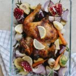 grilled whole chicken with vegetables and fruits in glass bowl