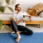 a man sitting on the floor while holding his water bottle
