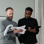 man in black dress shirt holding white paper