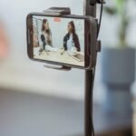 smartphone on tripod recording vlog with young multiethnic ladies