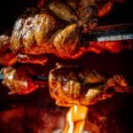 close up shot of roasted chickens in the rotisserie