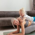 a woman doing exercise with her grandchild
