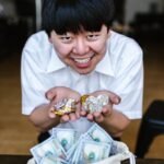 man in white button up shirt holding gold and silver coins