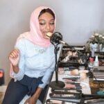 female vlogger in pink hijab using a condenser microphone