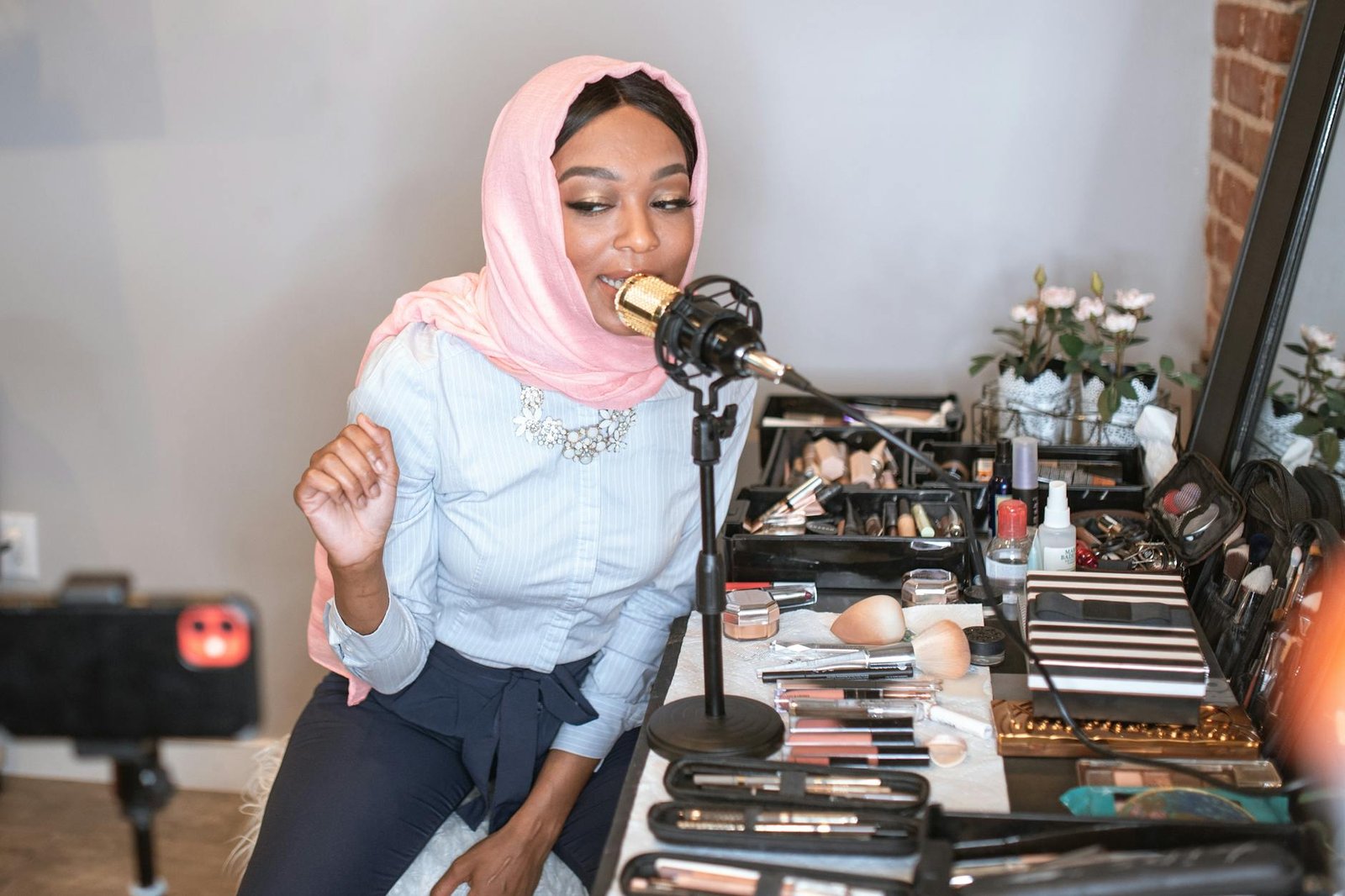 female vlogger in pink hijab using a condenser microphone