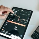 a black tablet with cryptocurrency data on screen