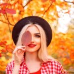 autumn portrait of stylish woman with red leaf
