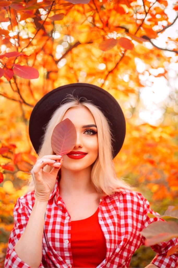 autumn portrait of stylish woman with red leaf