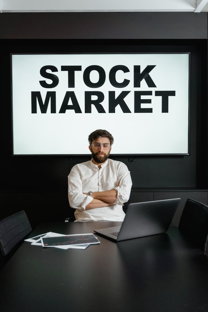a businessman in white dress shirt sitting by the table with arms crossed