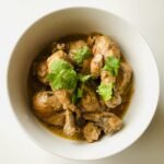 close up shot of delicious chicken curry in white ceramic bowl