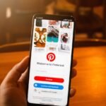 a person holding up a smartphone with the pinterest app on it