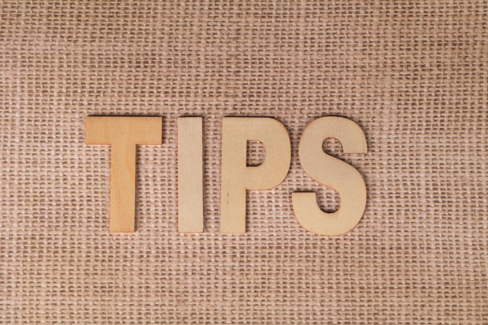 wooden letters on burlap background for tips