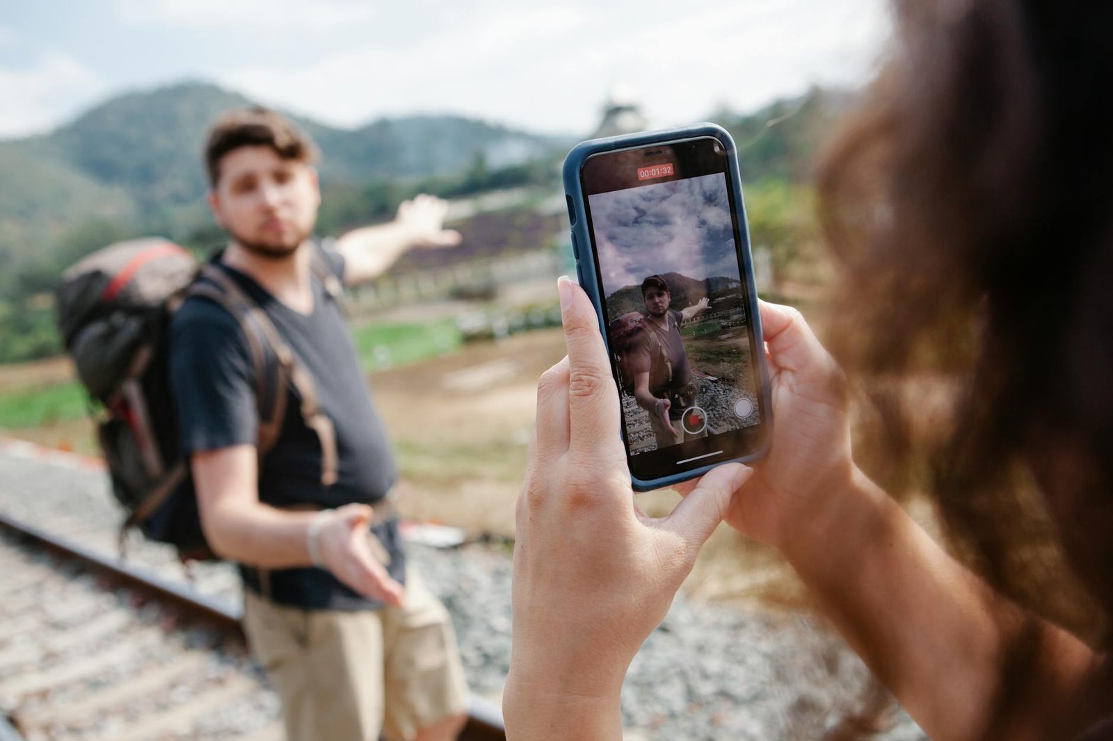 female taking video of traveler during hike in countryside in daylight