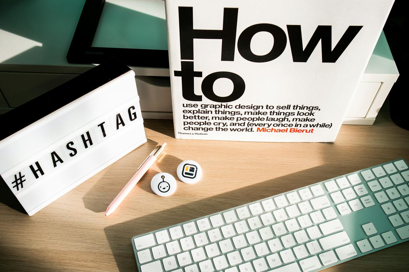 a keyboard light box with letters book and pen lying on a desk