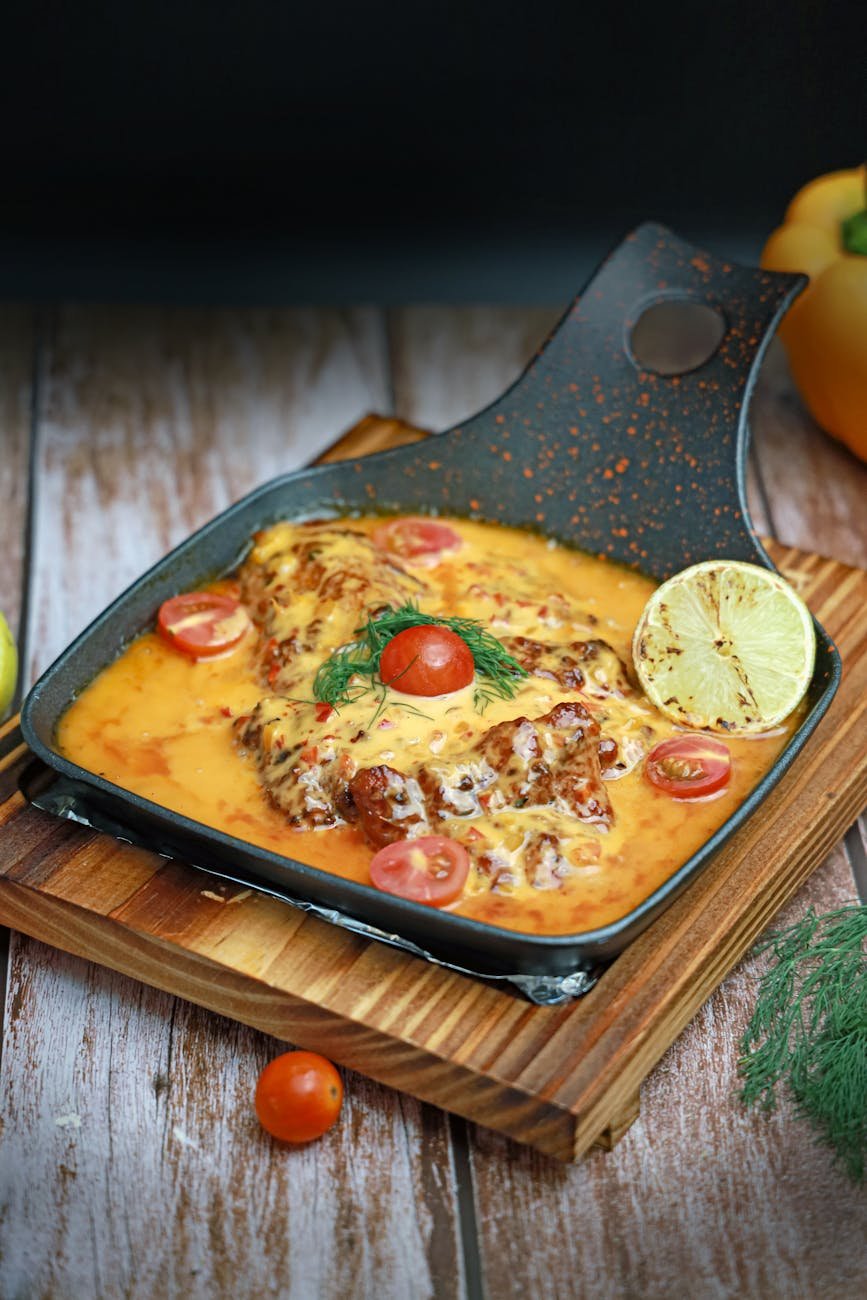 a pan with chicken and tomato sauce on top